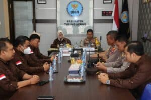 Mengawali sinergitas di awal tahun 2024, BNNK Tulungagung bersama Polres Tulungagung melaksanakan Penandatanganan Perjanjian Kerja Sama (PKS), Jumat (26/01). Penandatanganan ini dilaksanakan di Ruang Rapat Bangkit BNN Kabupaten Tulungagung, diwakili oleh Kepala Instansi masing – masing, yakni Rose Iptriwulandhani, S.Psi., M.M. selaku Kepala BNN Kabupaten Tulungagung dan AKBP Teuku Arsya Khadafi, S.H., S.I.K., M.Si. selaku Kapolres Tulungagung. Pada kesempatan tersebut, turut hadir pula Kasat Narkoba, IPTU Endro Purwandi, S.H. dan Kapolsek Kedungwaru, AKP Edy Santoso mendampingi Kapolres, serta Kasubbag Umum dan Para Ketua Tim Kerja Seksi BNN Kabupaten Tulungagung mendampingi Kepala BNNK Tulungagung. Kerja sama ini terkait dengan pelaksanakaan program Pencegahan, Pemberantasan, Penyalahgunaan dan Peredaran Gelap Narkotika dan Prekursor Narkotika (P4GN) di wilayah Kabupaten Tulungagung. Perjanjian Kerja Sama ini merupakan landasan bagi kedua belah pihak dalam penyebarluasan informasi dan edukasi (sosialisasi) tentang P4GN di wilayah kerja masing – masing. Selain itu, juga sebagai dasar pelaksanaan beberapa kegiatan seperti : Deteksi Dini P4GN melalui Pelaksanaan Tes Urine ; Pertukaran Data dan Informasi P4GN ; Pelaksanaan Operasi Bersama ; Asesmen Hukum terhadap Tersangka Narkotika ; Penyelidikan dan Penyidikan TPPU serta Pengamanan Kegiatan P4GN dan bidang lain yang disepakati. Sedangkan untuk ketentuan teknis dan operasional akan ditindaklanjuti dengan penyusunan Standar Operasional Prosedur (SOP) serta rencana implementasinya. Melalui sambutannya, Kepala BNNK Tulungagung, Rose Iptriwulandhani, S.Psi., M.M. menjelaskan berbagai program BNN seperti Desa Bersinar, Kabupaten / Kota Tanggap Ancaman Narkoba, Ketahanan Keluarga, dan sebagainya memerlukan kerja sama dengan berbagai pihak, termasuk sinergitas bersama Polres Tulungagung. Ini merupakan awal yang baik untuk mengoptimalkan kerja sama dan kolaborasi dalam pelaksanaan program P4GN, tidak hanya sekedar formalitas di atas kertas saja. Beliau juga menyampaikan terima kasih atas terlaksananya Penandatanganan Perjanjian Kerja Sama antara BNNK Tulungagung dengan Polres Tulungagung. “Kami berterima kasih kepada pihak Polres atas kesediannya telah berkenan menjalin kerjasama dengan BNNK Tulungagung. Semoga mampu meningkatkan sinergitas, kolaborasi serta bekerja sama mewujudkan Tulungagung Bersinar, serta Indonesia Bersinar, Bersih Narkoba.” Sementara itu, Kapolres Tulungagung mengapresiasi pelaksanaan Penandatanganan PKS pada hari ini. Melalui sambutannya, beliau menyampaikan bahwa penandatanganan ini merupakan kegiatan rutin yang dilaksanakan setiap tahun guna memenuhi persyaratan formil terkait perjanjian kerja sama. Beliau juga prihatin atas kasus penyalahgunaan dan peredaran gelap narkoba telah merambah berbagai kalangan, dari oknum Kepala Desa, Perangkat Desa, Anggota Legislatif, Guru, Ibu Rumah Tangga, PNS bahkan Aparat Penegak Hukum. Merupakan hal yang sangat miris, karena mereka menggunakan bukan disebabkan ketidaktahuan terhadap bahaya narkotika, melainkan dorongan hasrat kenikmatan sesaat. Terlebih, peredaran sudah merambah ke anak di bawah umur sehingga memicu perilaku agresif dan kekerasan kelompok, meskipun kasusnya belum termasuk pada kategori peyalahgunaan narkotika maupun psikotropika. “Ini tidak menyurutkan semangat kerja kami dari Kepolisian, untuk bersama – sama dengan BNN memberantas peredaran gelap narkoba. Karena kejahatan narkoba merupakan kejahatan yang merusak generasi bangsa. Bahkan memiliki potensi merusak dua puluh tahun ke depan,” tegasnya. Mengawali sinergitas di awal tahun 2024, BNNK Tulungagung bersama Polres Tulungagung melaksanakan Penandatanganan Perjanjian Kerja Sama (PKS), Jumat (26/01). Penandatanganan ini dilaksanakan di Ruang Rapat Bangkit BNN Kabupaten Tulungagung, diwakili oleh Kepala Instansi masing – masing, yakni Rose Iptriwulandhani, S.Psi., M.M. selaku Kepala BNN Kabupaten Tulungagung dan AKBP Teuku Arsya Khadafi, S.H., S.I.K., M.Si. selaku Kapolres Tulungagung. Pada kesempatan tersebut, turut hadir pula Kasat Narkoba, IPTU Endro Purwandi, S.H. dan Kapolsek Kedungwaru, AKP Edy Santoso mendampingi Kapolres, serta Kasubbag Umum dan Para Ketua Tim Kerja Seksi BNN Kabupaten Tulungagung mendampingi Kepala BNNK Tulungagung. Kerja sama ini terkait dengan pelaksanakaan program Pencegahan, Pemberantasan, Penyalahgunaan dan Peredaran Gelap Narkotika dan Prekursor Narkotika (P4GN) di wilayah Kabupaten Tulungagung. Perjanjian Kerja Sama ini merupakan landasan bagi kedua belah pihak dalam penyebarluasan informasi dan edukasi (sosialisasi) tentang P4GN di wilayah kerja masing – masing. Selain itu, juga sebagai dasar pelaksanaan beberapa kegiatan seperti : Deteksi Dini P4GN melalui Pelaksanaan Tes Urine ; Pertukaran Data dan Informasi P4GN ; Pelaksanaan Operasi Bersama ; Asesmen Hukum terhadap Tersangka Narkotika ; Penyelidikan dan Penyidikan TPPU serta Pengamanan Kegiatan P4GN dan bidang lain yang disepakati. Sedangkan untuk ketentuan teknis dan operasional akan ditindaklanjuti dengan penyusunan Standar Operasional Prosedur (SOP) serta rencana implementasinya. Melalui sambutannya, Kepala BNNK Tulungagung, Rose Iptriwulandhani, S.Psi., M.M. menjelaskan berbagai program BNN seperti Desa Bersinar, Kabupaten / Kota Tanggap Ancaman Narkoba, Ketahanan Keluarga, dan sebagainya memerlukan kerja sama dengan berbagai pihak, termasuk sinergitas bersama Polres Tulungagung. Ini merupakan awal yang baik untuk mengoptimalkan kerja sama dan kolaborasi dalam pelaksanaan program P4GN, tidak hanya sekedar formalitas di atas kertas saja. Beliau juga menyampaikan terima kasih atas terlaksananya Penandatanganan Perjanjian Kerja Sama antara BNNK Tulungagung dengan Polres Tulungagung. “Kami berterima kasih kepada pihak Polres atas kesediannya telah berkenan menjalin kerjasama dengan BNNK Tulungagung. Semoga mampu meningkatkan sinergitas, kolaborasi serta bekerja sama mewujudkan Tulungagung Bersinar, serta Indonesia Bersinar, Bersih Narkoba.” Sementara itu, Kapolres Tulungagung mengapresiasi pelaksanaan Penandatanganan PKS pada hari ini. Melalui sambutannya, beliau menyampaikan bahwa penandatanganan ini merupakan kegiatan rutin yang dilaksanakan setiap tahun guna memenuhi persyaratan formil terkait perjanjian kerja sama. Beliau juga prihatin atas kasus penyalahgunaan dan peredaran gelap narkoba telah merambah berbagai kalangan, dari oknum Kepala Desa, Perangkat Desa, Anggota Legislatif, Guru, Ibu Rumah Tangga, PNS bahkan Aparat Penegak Hukum. Merupakan hal yang sangat miris, karena mereka menggunakan bukan disebabkan ketidaktahuan terhadap bahaya narkotika, melainkan dorongan hasrat kenikmatan sesaat. Terlebih, peredaran sudah merambah ke anak di bawah umur sehingga memicu perilaku agresif dan kekerasan kelompok, meskipun kasusnya belum termasuk pada kategori peyalahgunaan narkotika maupun psikotropika. “Ini tidak menyurutkan semangat kerja kami dari Kepolisian, untuk bersama – sama dengan BNN memberantas peredaran gelap narkoba. Karena kejahatan narkoba merupakan kejahatan yang merusak generasi bangsa. Bahkan memiliki potensi merusak dua puluh tahun ke depan,” tegasnya.